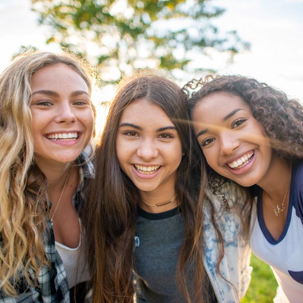 three smiling teenage girls