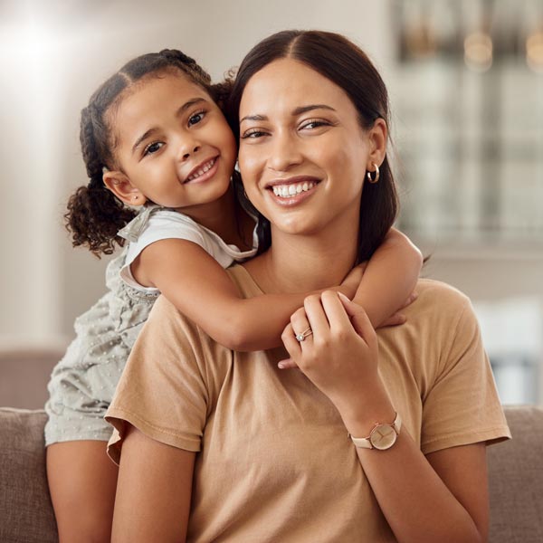 mother and young daughter smiling